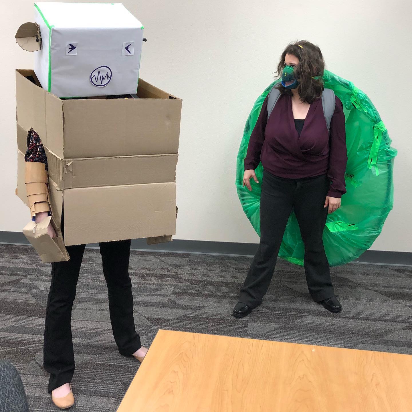 Actors standing in handmade giant cardboard box robot and giant turtle costumes.